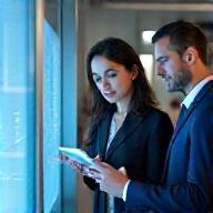 Two business people discussing fintech strategies on a tablet